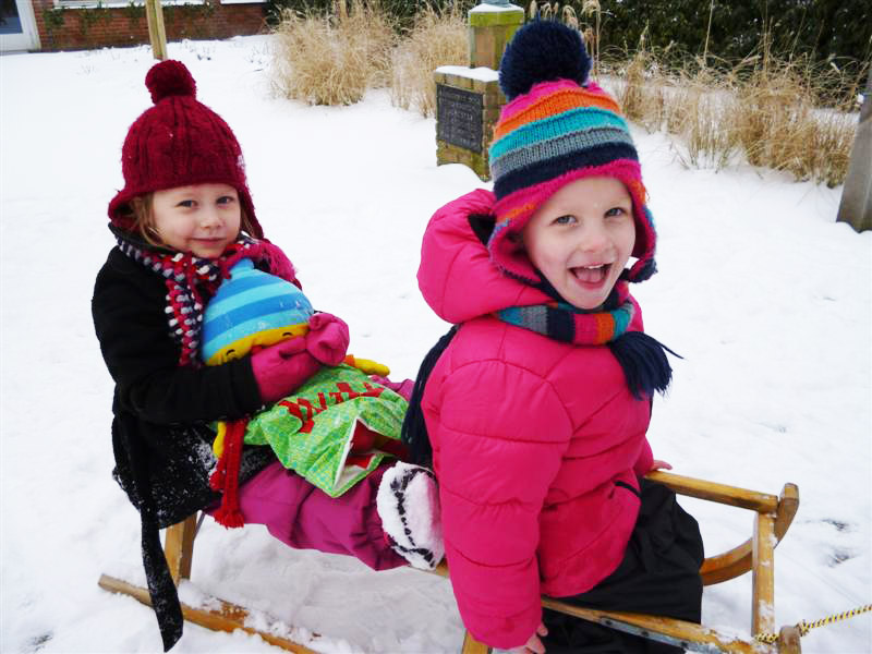 Kinderen ’t Hoepeltje spelen in de sneeuw bij de buren van Magnushof